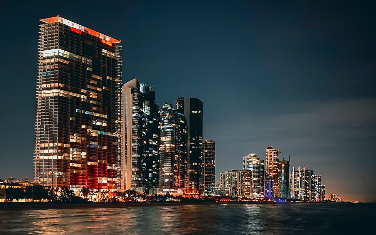 High-rise condominium and condo hotel towers lit at night along the Miami shoreline
